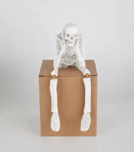 Gedetailleerd overzicht van een wit hars skeletbeeldje op een bruine doos voor Halloween.
