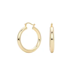 Detail view of polished gold S925 sterling silver hollow tube hoop earrings with latch back