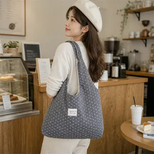 Large capacity grey polka dot tote bag shown in a cozy cafe lifestyle scene