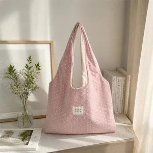 Casual pink star pattern tote bag displayed in a cozy lifestyle indoor setting.