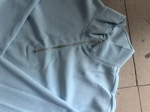 Primer plano de una sudadera de punto acanalado azul claro para hombre con cuello de cremallera