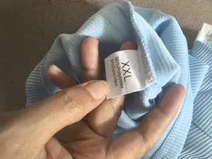 Primer plano de la etiqueta de lavado en una sudadera de punto celeste para hombre