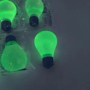 Close-up showing the vivid green glow-in-the-dark effect of lightbulb squishy toys