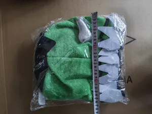 Detailed view of a green plush monster party hat with a measuring tape showing dimensions