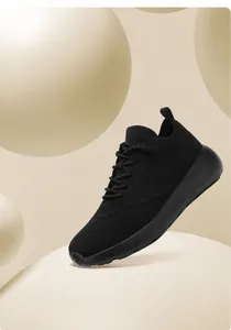 Nahaufnahme eines schwarzen atmungsaktiven Mesh-Sneakers mit EVA-Sohle auf Beige
