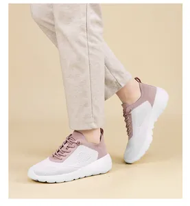 Nahaufnahme von atmungsaktiven pink-weißen Mesh-Sneakern an den Füßen des Models