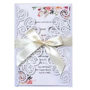 Elegante invitación de boda blanca cortada con láser con lazo crema y flores