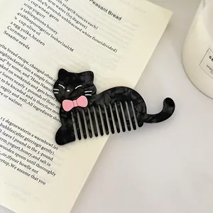 Peigne à cheveux chat noir en acétate avec nœud rose, design à dents larges.