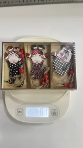 Detail showing a set of 3 wooden Christmas gnome ornaments on a scale weighing 48.1g.