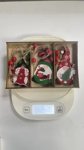 Close-up view of wooden Christmas gnome ornaments on a scale showing 57.0g weight
