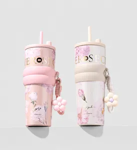 Close-up of floral insulated tumblers featuring straw lids and cute flower charms