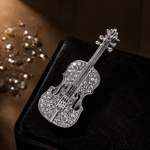 Detailed view of an elegant violin-shaped brooch with sparkling rhinestone accents