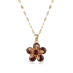 Elegant gold necklace with a rotating red zircon flower pendant on a white background.