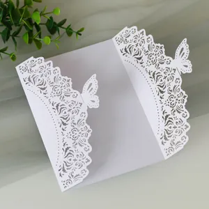 Dettaglio dell'elegante invito di nozze bianco tagliato al laser con fiori e farfalle