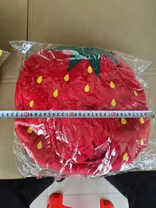 Gedetailleerd overzicht van pluche aardbeienhoofddeksel gemeten met een metalen meetlint