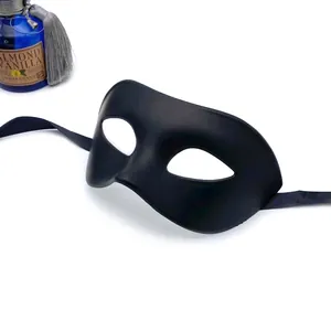 Detail showing a matte black masquerade half mask with satin ribbon ties for party