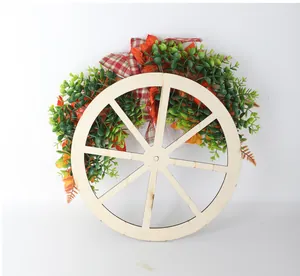 Autumn wreath with wooden wagon wheel, maple leaves and pumpkins for Thanksgiving