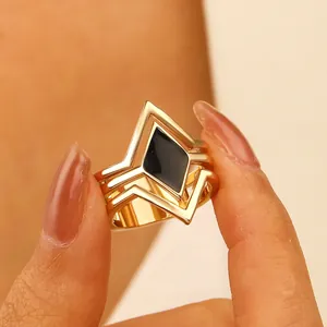 Close-up detail of a vintage geometric multi-layer ring with black enamel rhombus center.