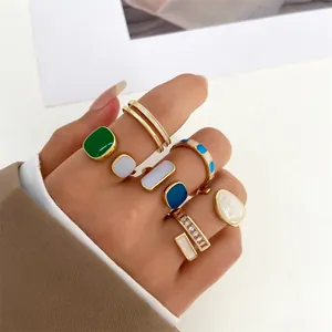 Close-up view of vintage geometric enamel rings set in gold finish worn on fingers