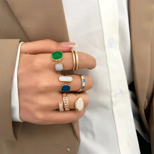 Detailed view of vintage gold plated geometric enamel stackable rings on hand with blazer