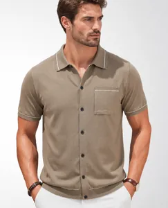 Close-up of a men's khaki knit Polo shirt with white piping and chest pocket