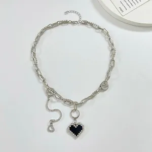 Detail view of silver punk heart necklace with layered chains and rhinestone accents