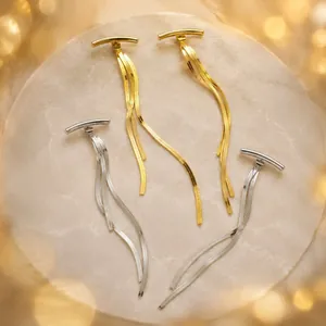 Detailed view of elegant gold and silver snake chain tassel earrings on marble display