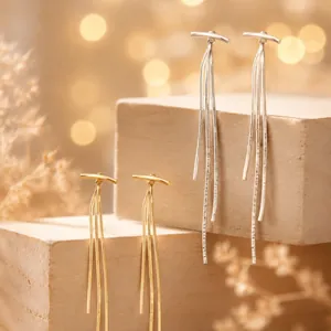 Detailed display of long tassel earrings in gold and silver finishes on a wooden stand
