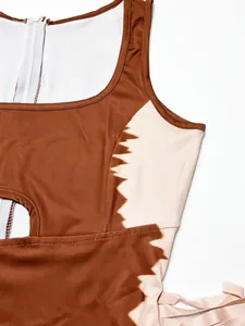 Close-up detail of a fashion color-block bodysuit with side cutout and tassel accents