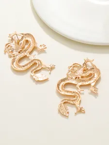 Close-up of fashionable gold-plated dragon-shaped stud earrings with intricate textures
