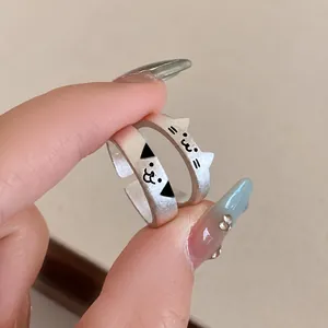 Close-up of cute matte silver cat rings with adjustable open band and minimalist face
