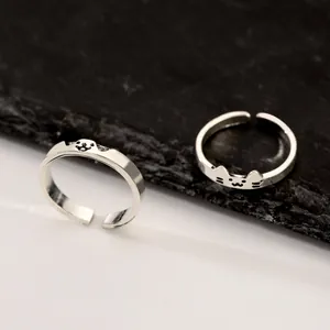 Macro detail view of two adjustable silver animal rings featuring cute cat and seal motifs