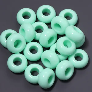 Primo piano di perline acriliche verde menta da 13 mm con fori grandi per gioielli