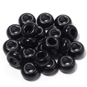 Dettaglio macro di perline in acrilico nero lucido da 13mm con fori grandi per DIY