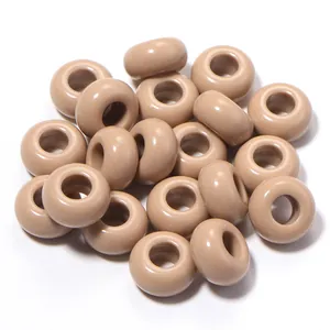 Dettaglio macro di perle in acrilico beige da 13 mm con foro grande per gioielli fai da te