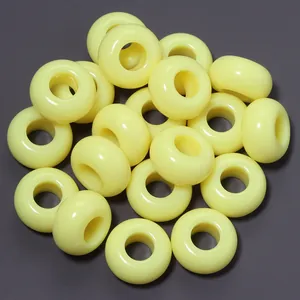 Primo piano di perline in acrilico giallo brillante da 13 mm con foro grande per DIY