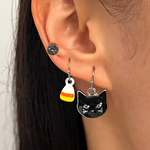 Detailed close-up of Halloween drop earrings featuring a black cat and candy corn design