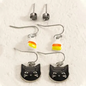 Detailed view of Halloween earring set featuring black cat and candy corn charms