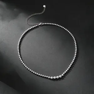 Close-up of s925 silver moissanite tennis necklace on a textured black background.