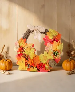 Autumn wreath scene display with maple leaves and burlap bow on wooden background