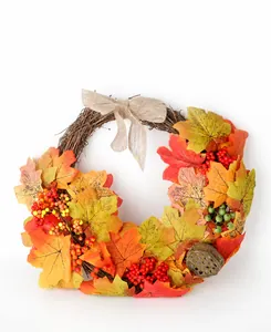 Close-up of autumn maple leaf wreath with rustic burlap bow and decorative red berries