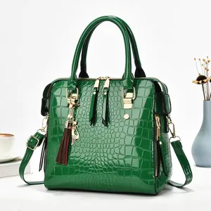 Elegant green crocodile-patterned patent leather handbag with gold-tone hardware detail.