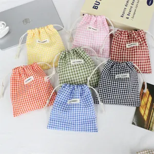 Détail rapproché de pochettes à cordon en coton à carreaux multicolores pour petits objets