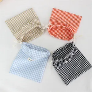 Lot de quatre pochettes de rangement à cordon en vichy bleu, orange, beige et noir