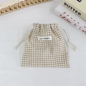 Détail de la pochette de rangement à cordon vichy beige pour rouge à lèvres.