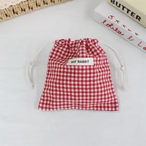 Détail d'un petit sac à cordon en coton à carreaux rouges et blancs pour l'organisation