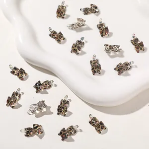 Detailed view of multiple leopard print resin cat charms for DIY phone case jewelry