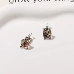 Detailed macro view of cute leopard print cat resin charms for DIY craft jewelry making