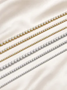 Macro detail of various sized cubic zirconia tennis bracelets in gold and silver steel.