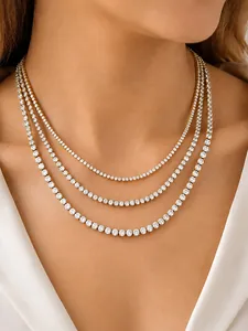 Close-up of triple-layered gold tennis necklaces with sparkling white cubic zirconia